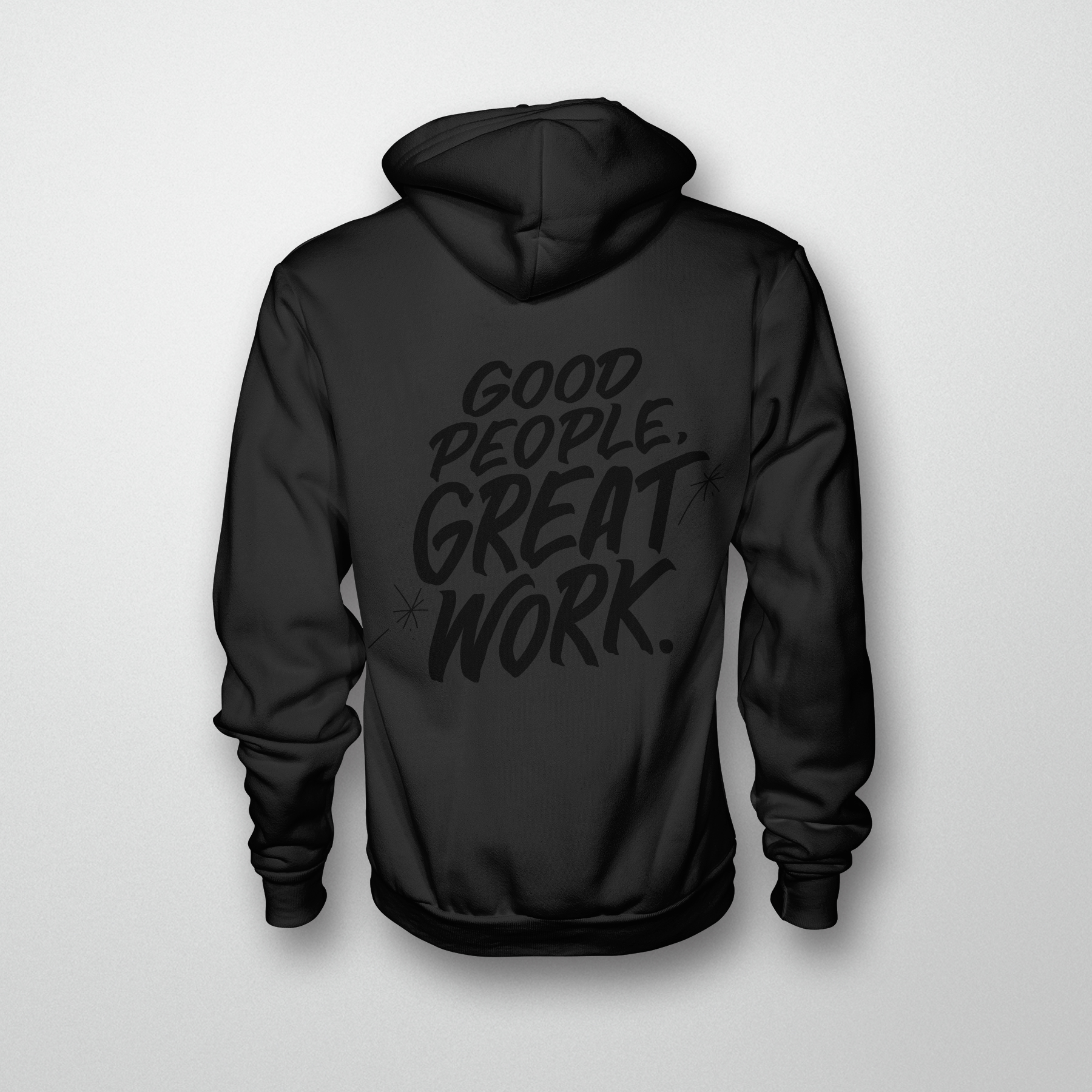 A black hoodie with shiny black text in the style of Honest Eds reads Good people great work.